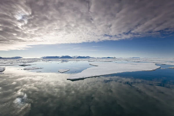 Norway, Svalbard, Edgeoya Island, Low clouds reflected in sea with fractured first