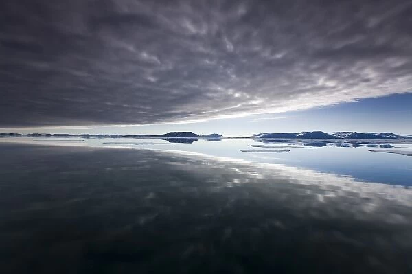 Norway, Svalbard, Edgeoya Island, Reflection of low clouds in calm sea on summer