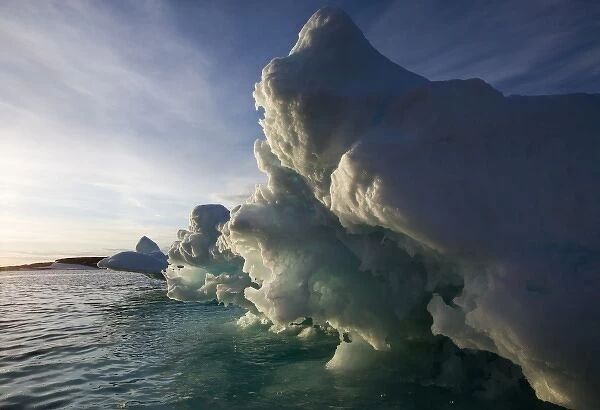 Norway, Svalbard, Langoya Island, Setting sun lights glacial iceberg on summer evening