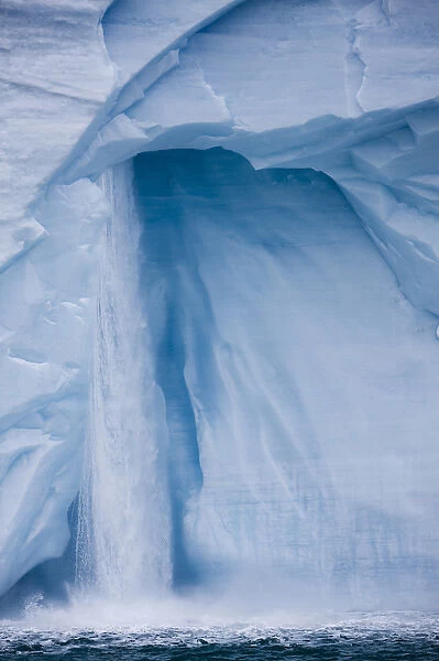 Norway, Svalbard, Nordaustlandet, Waterfall pours from ice face of Brasvellbreen