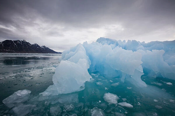 Norway, Svalbard, Spitsbergen, Deep blue iceberg floating near face of Lilliehook