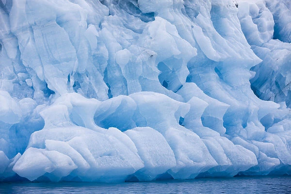 Norway, Svalbard, Spitsbergen Island, Patterns in melting iceberg floating near face