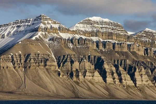 Norway, Svalbard, Spitsbergen Island, Setting midnight sun lights eroded cliffs