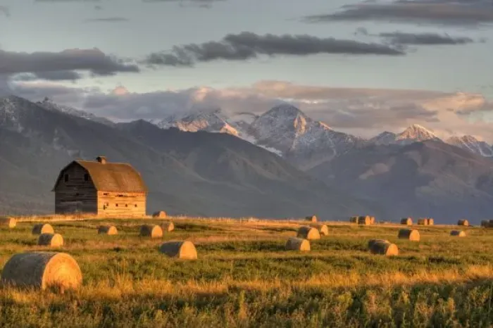 Framed Print : Old barn framed by hay bales and dramatic Mission Mountain Range in Montana