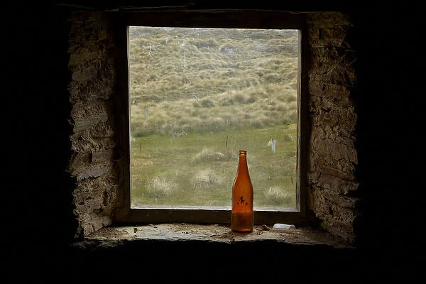 Old bottle in window of Potters Huts, by historic gold fields, Old Man Range, Southland