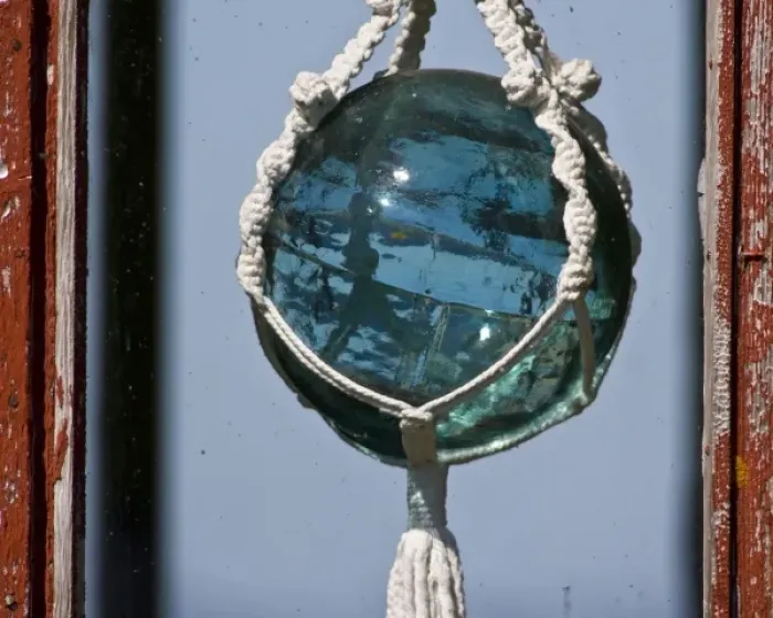 Framed Print : Old-fashioned glass float used in fishing nets hangs in window near Latrabjerg, Iceland Framed Print : Old-fashioned glass float used in fishing nets hangs in window near Latrabjerg, Iceland