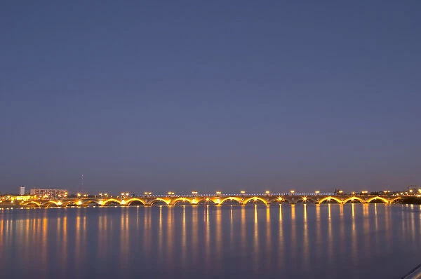 The old Pont de Pierre bridgeat night with reflections in Bordeaux on the Garonne