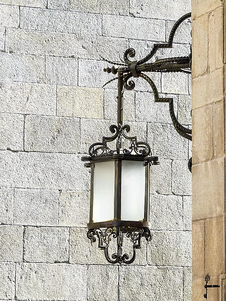 Old street lamp hanging in the streets of Santiago de Compostela