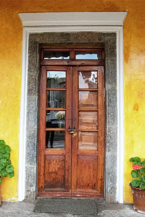 Framed Print : Old wooden doorway flanked by two geranium plants at Hacienda San Augustin de Callo in the Cotopaxi region of Ecuador. (Editorial Use Only)