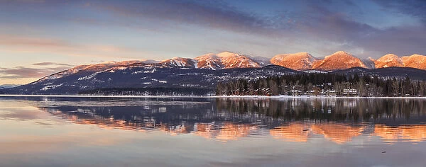 Panoramic of Big Mountain reflects into Whitefish Lake at sunset in winter in Whitefish