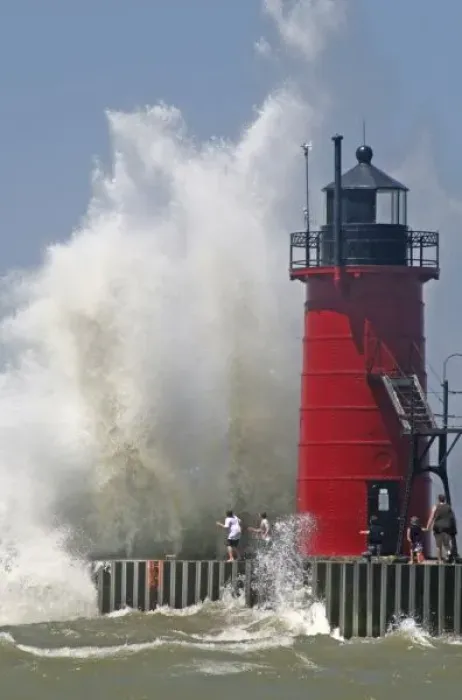 Framed Print : People on jetty watch large breaking waves in South Haven Michigan