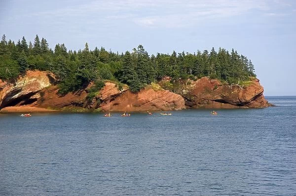 People sea kayaking in the Bay of Fundy at St. Martins, New Brunswick, Canada