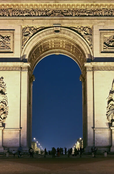 People standing under the Arc de Triomphe at night, Paris, France