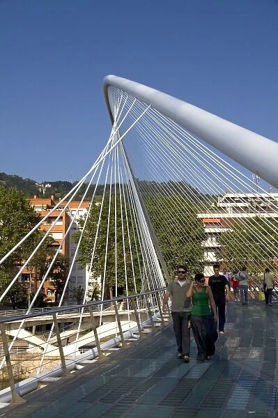 People walking across the Zubizuri Footbridge spanning the Nervion River in Bilbao