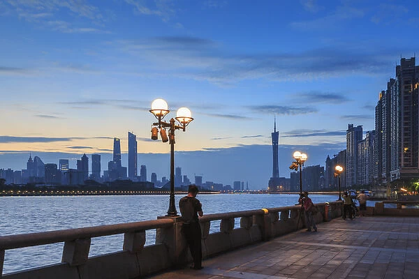 person on smarphone, view along Pearl River of city skyline from Yacht Club, Guangzhou