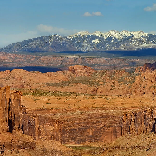 Photo taken from Long Canyon with badlands and snow capped La Sal Mountains in distance