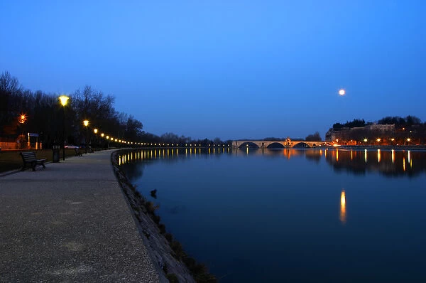 The Pont Saint St Benezet bridge in Avignon on the Rhone at sunset with moon and the river bank