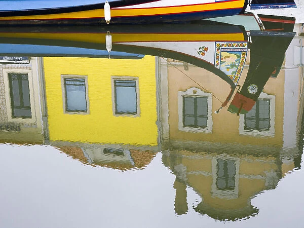 Portugal, Aveiro. Reflection of colorful buildings and painted Moliceiro boats in