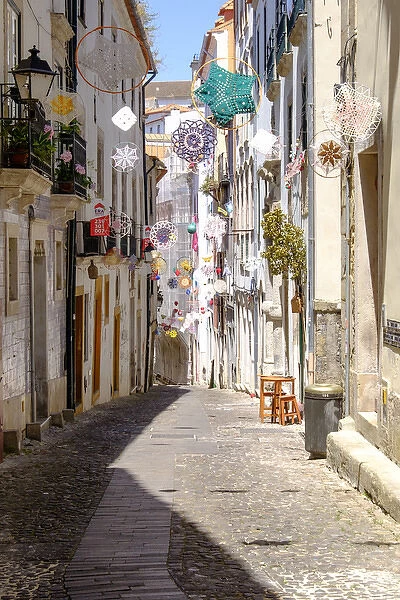 Portugal, Coimbra. Narrow Cobblestone streets in the old section of town, decorated