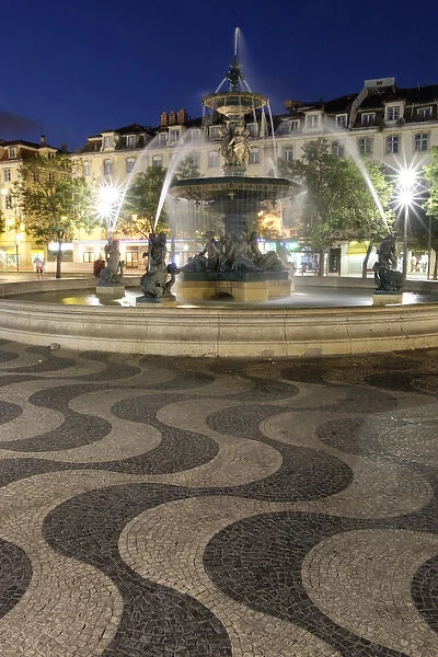 Portugal, Lisbon. Rossio Square at night. Bronze Mermaid Fountain
