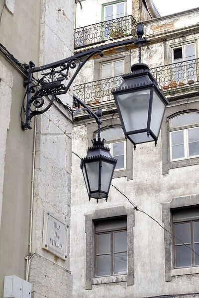Portugal, Lisbon. Wrought iron street lights on corner of building