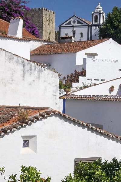 Portugal, Obidos. Ancient, red, terra cotta tiled roof tops, lines. Old windows