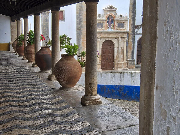 Portugal, Obidos. Ceramic pots adorning a building ledge