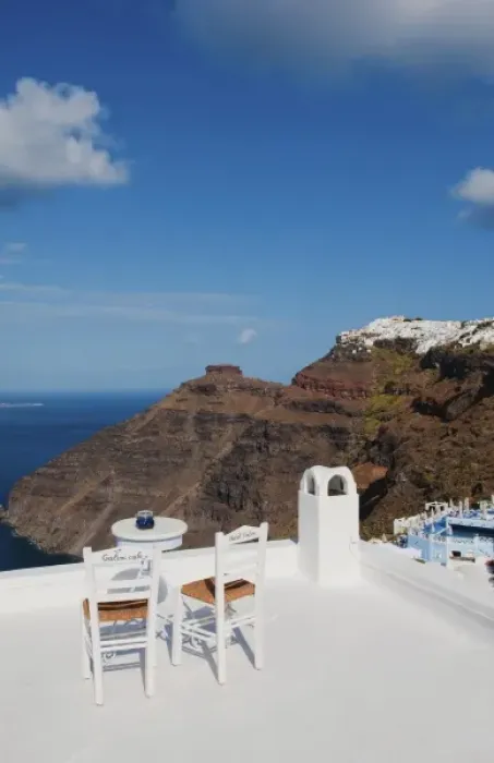 Framed Print : Postcard scene of two lonely chairs on terrace with table ready for tourists in Santorini
