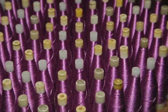 Framed Print : Purple silk thread wound on bobbins stacked in rows at a silk weaving factory, Chiang Mai