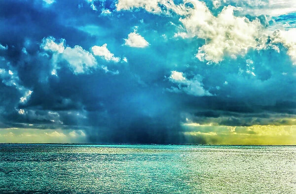 Rain storm cloud, Moorea, Tahiti, French Polynesia. Different blue colors from lagoon and coral reefs