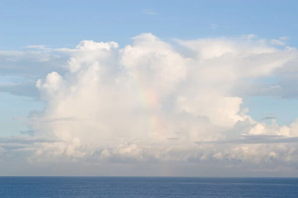 A rainbow in cumulus clouds forming over the Caribbean Sea near Barbados