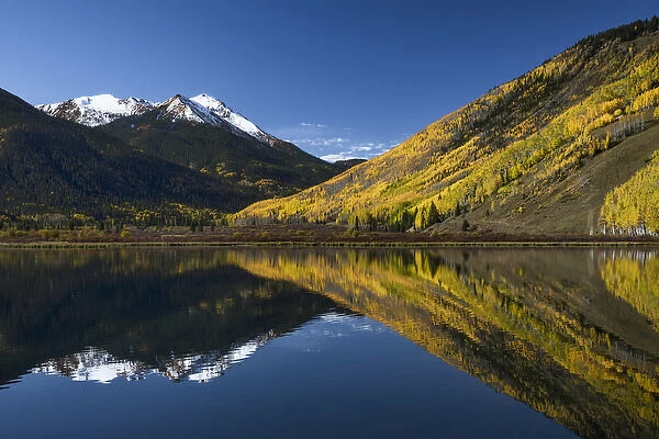 Red Mountain and autumn aspen trees reflected on Crystal Lake at sunrise, near Ouray