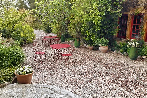 Red tables and chairs in outdoor sitting area, Provence region of southern France