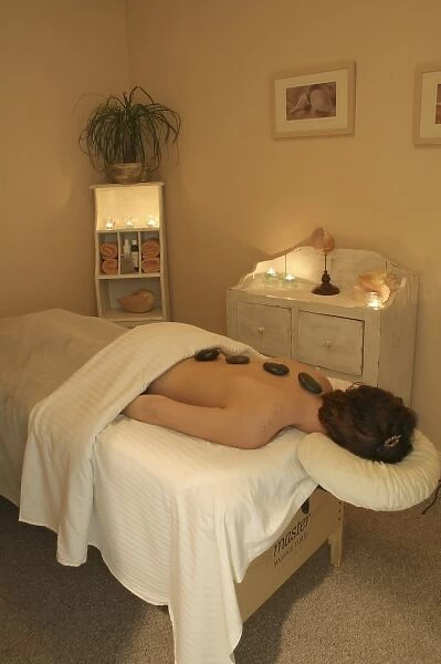 Released health spa woman heated stones on back