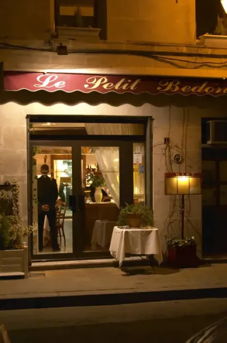 Framed Print : The restaurant Le Petit Bedon at night with the waiter standing inside the door. Avignon