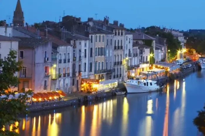 Framed Print : Restaurants along the l Herault river. L Herault river. A fishing boat. Agde town
