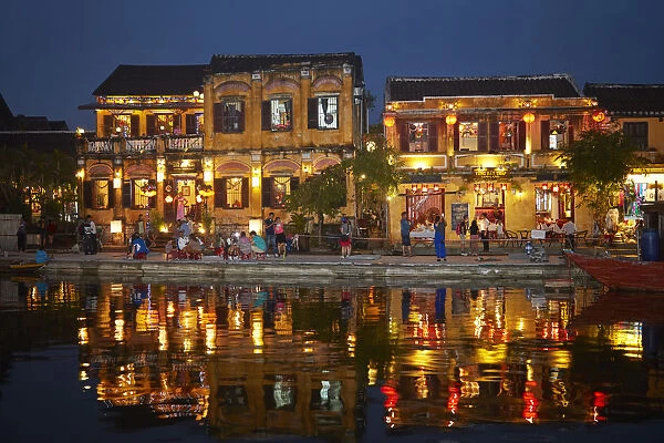 Restaurants and tourists reflected in Thu Bon River at dusk, Hoi An (UNESCO World Heritage Site)