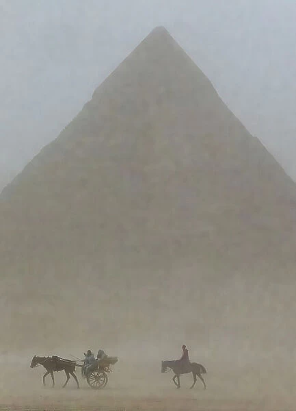 Riders in sandstorm. Pyramids of Giza, Egypt