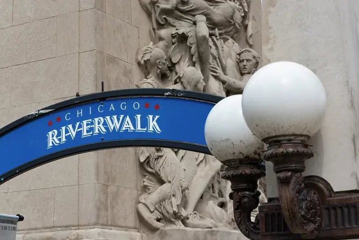 Framed Print : Riverwalk signage along the Chicago River in downtown Chicago with Michigan Avenue McCormick Bridgehouse bas-relief