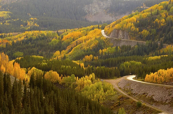 A road meanders through the brilliant fall colors of the San Juan Mountains of Colorado