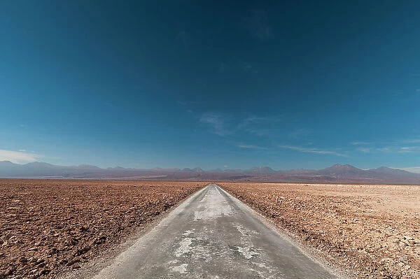 An empty road through a salt flat in the Salar de Atacama. Salar de Atacama, Atacama Desert, Antofagasta Region, Chile