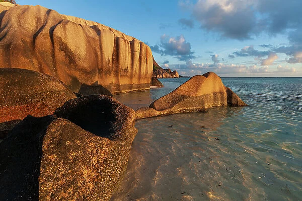 Rock formations on a tropical island beach in warm sunlight at sunset. Anse Source d Argent Beach, La Digue Island, Seychelles