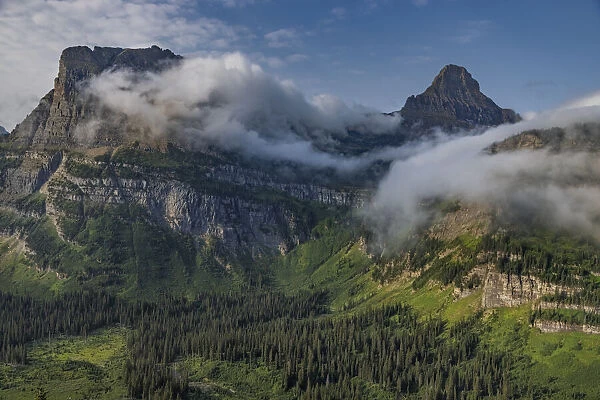 Rolling fog clouds with Heavy Runner and Reynold Mountains at Logan Pass in Glacier National Park, USA