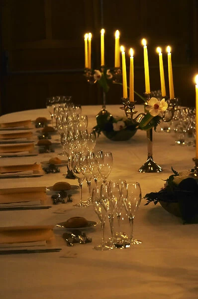 A romantic table set for wine tasting and dinner with many glasses and candelabra