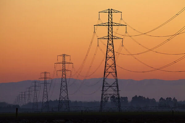 Row of power pylons at sunset, Mid Canterbury, South Island, New Zealand