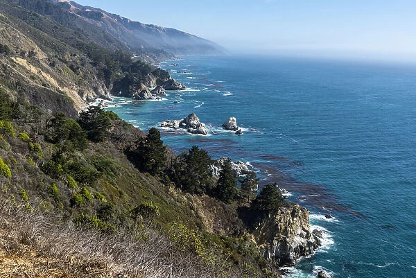 The rugged coastline of Big Sur, California. with wisps of fog floating into the hills