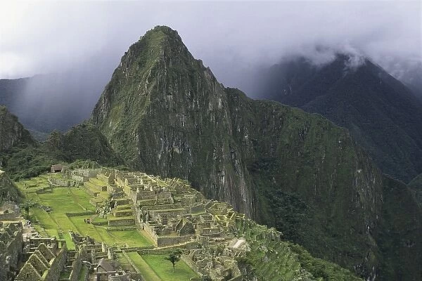 The ruins of the Machu Picchu citadel lie between the peak of Huayna Picchu and the
