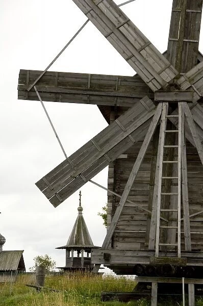 Russia, Lake Onega, Kizhi Island. Windmill with historic 9-domed Intercession Church