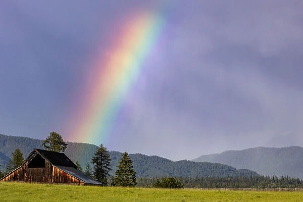 Rustic weathered barn with rainbow in Whitefish, Montana, USA