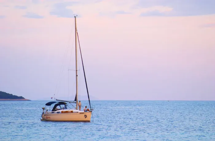 Framed Print : A sailing boat moored in the bay with two people on the deck off Korcula at sunset Framed Print : A sailing boat moored in the bay with two people on the deck off Korcula at sunset